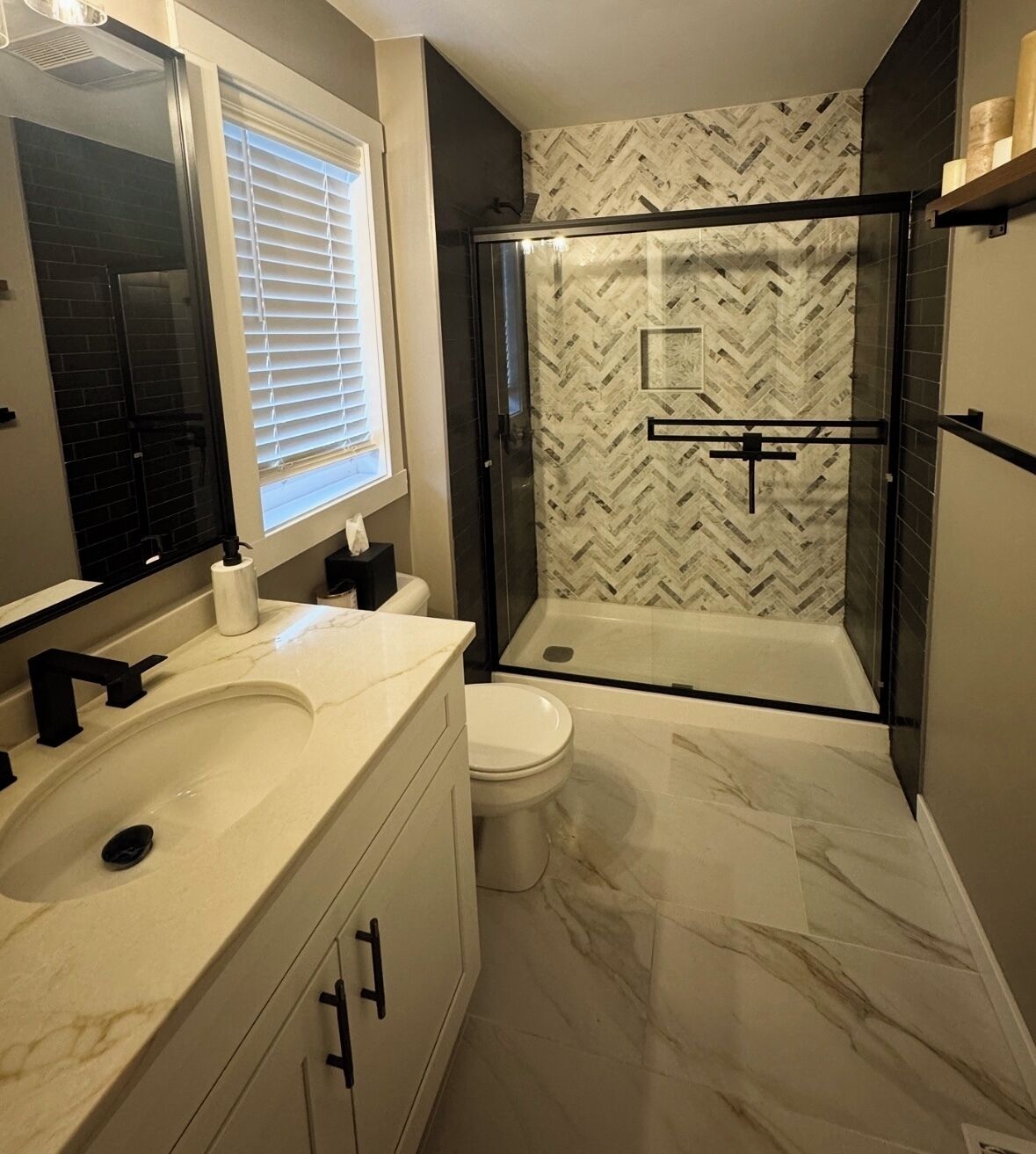 Un baño con ducha envuelta en vidrio, inodoro y lavabo con espejo.