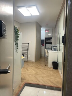 A modern kitchen with a microwave, a refrigerator, and a sink. There is a plant on the wall and a black trash bin. - Korea Univ. simple house 2-bedroom HOUSE Seoul (Seoul)
