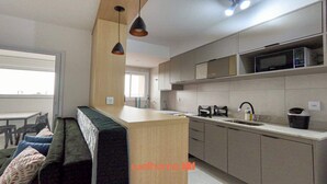 Una cocina moderna con una isla central, microondas integrado y un fregadero.