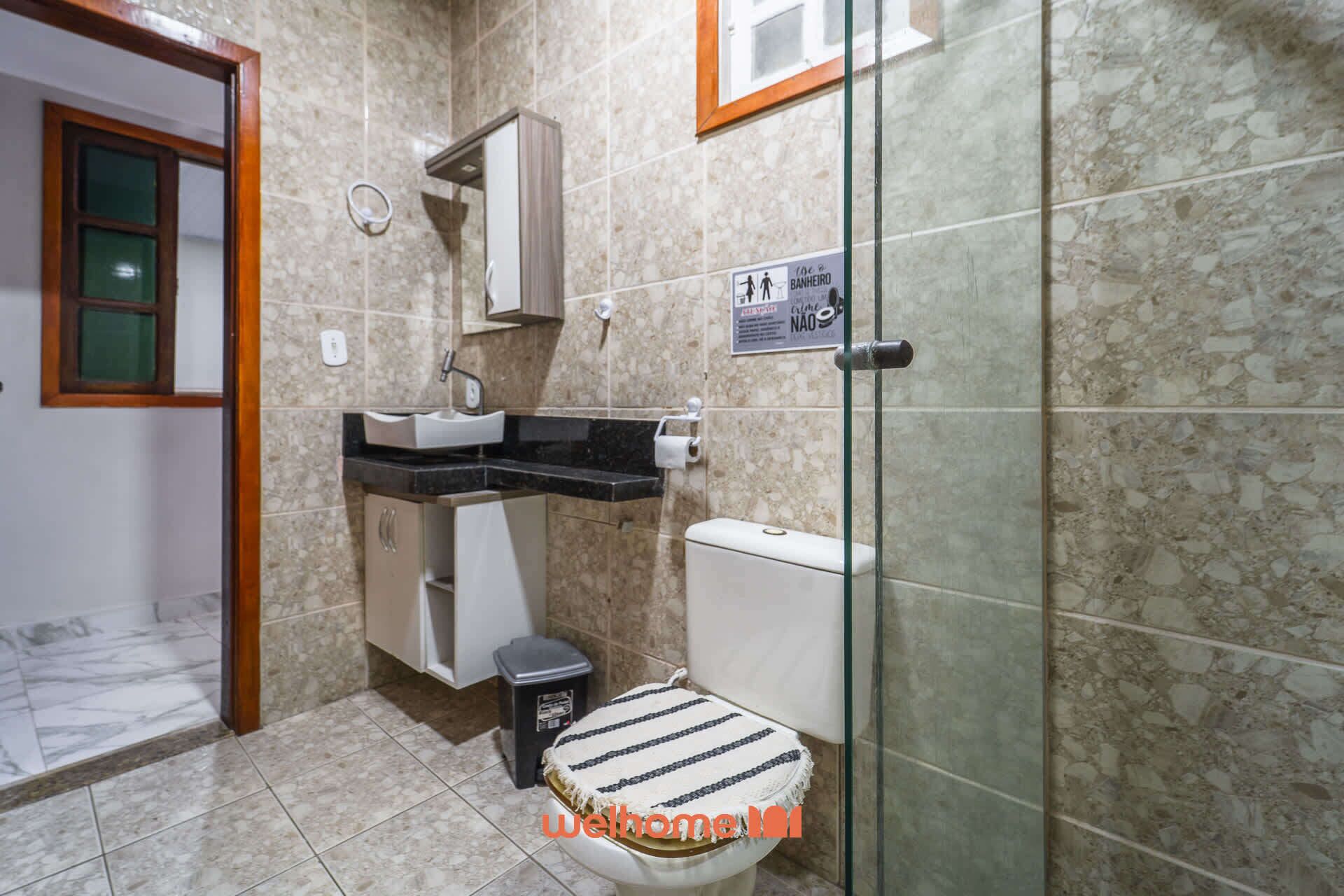 A bathroom with a sink, mirror, toilet, and a glass shower enclosure.