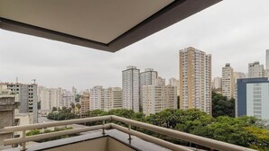 Un paisaje urbano con rascacielos y un balcón con barandilla.