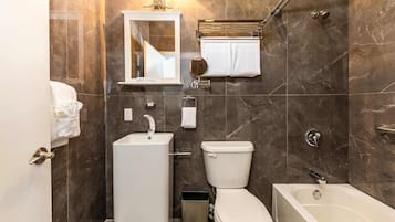 A modern bathroom with a toilet, sink, and bathtub.