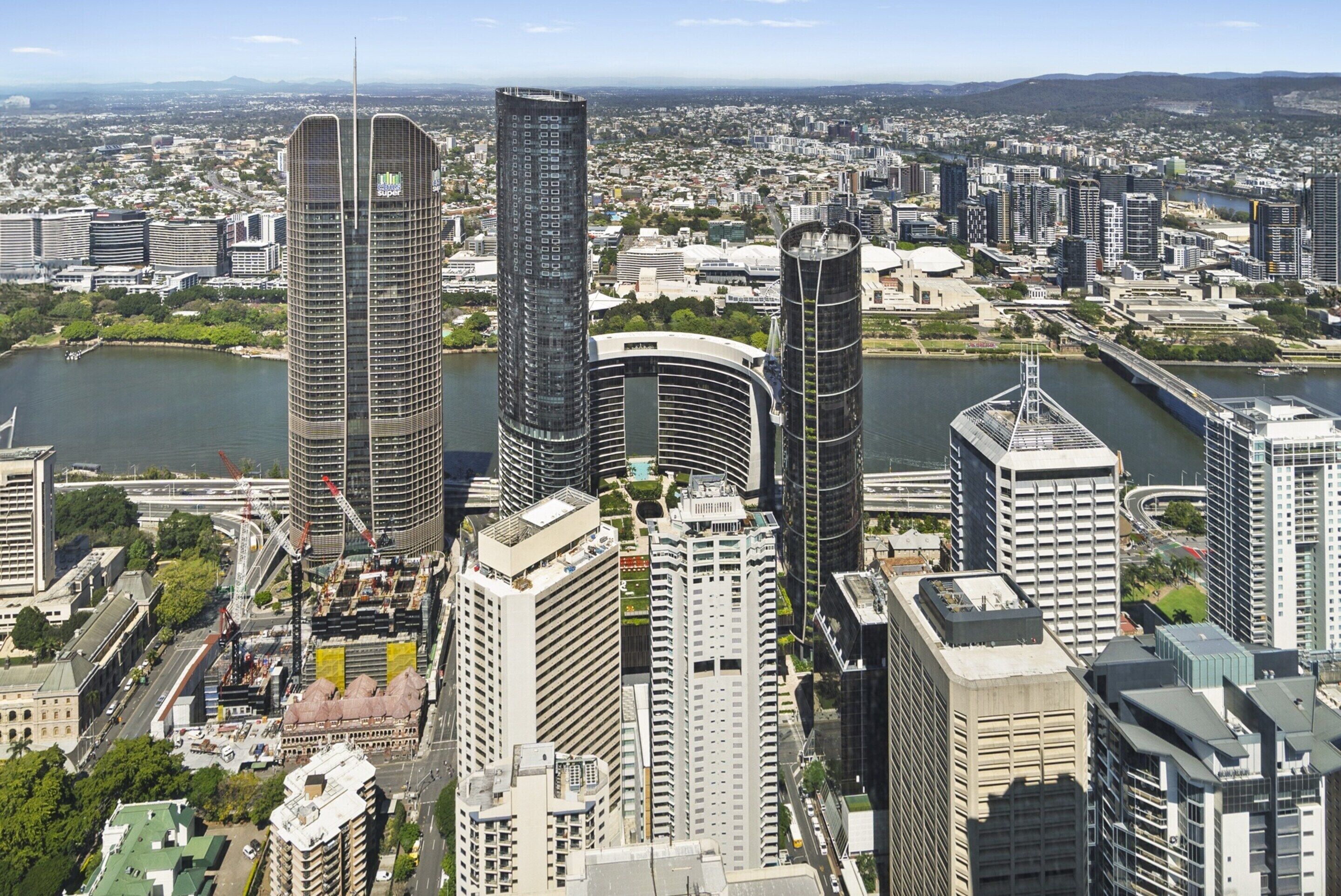 A cityscape with modern high-rise buildings, a river, and a bridge.