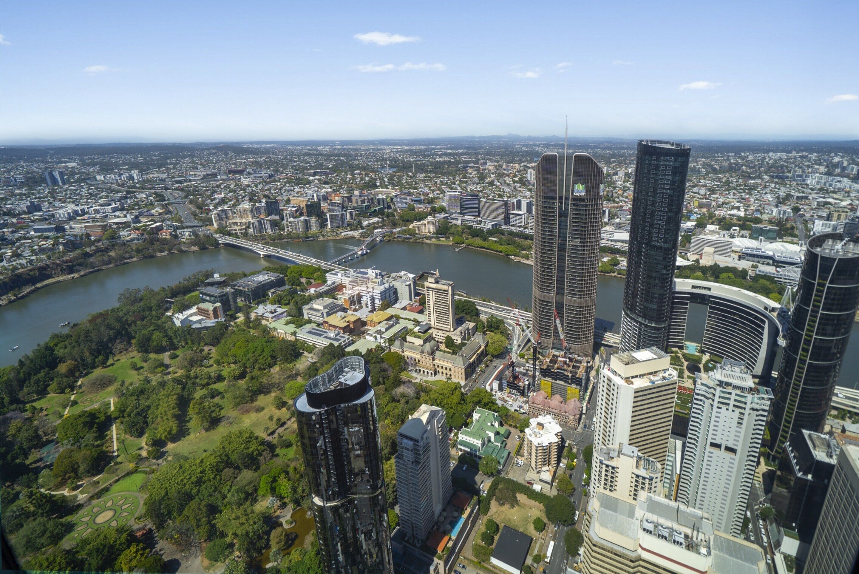 Ein Hochhaus mit modernem Design, umgeben von weiteren Hochhäusern und einem Fluss.