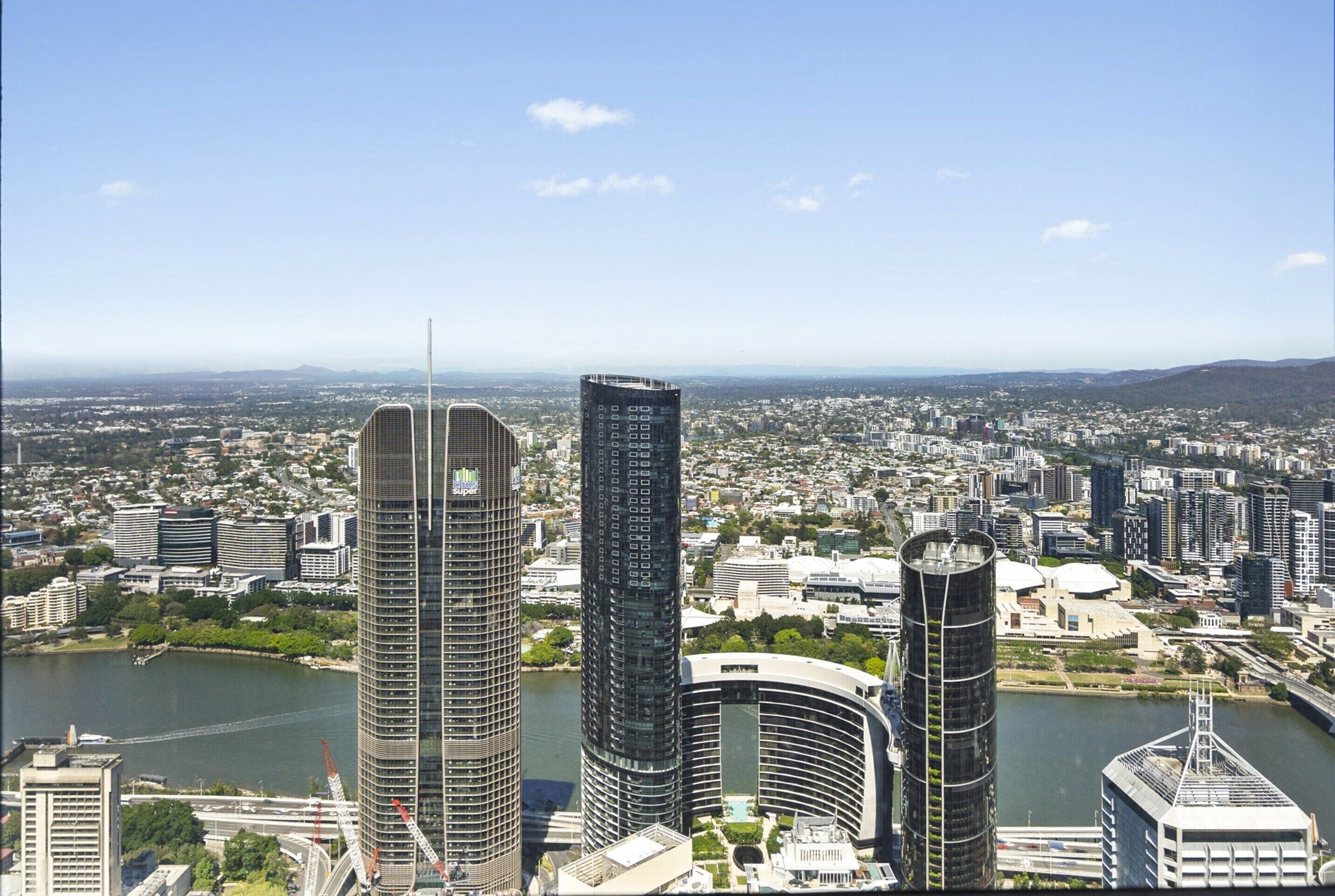 A cityscape with modern high-rise buildings, a river, and a bridge.