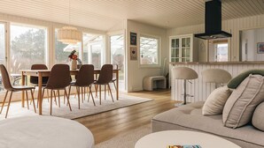 Un intérieur moderne comprenant un coin repas, une cuisine et un salon.