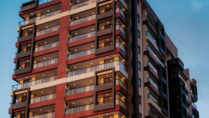 A multi-story building with balconies and a sign that reads "SSN INCORPORACAOES". - Apartment across from the beach for millionaires. (Ilhéus)
