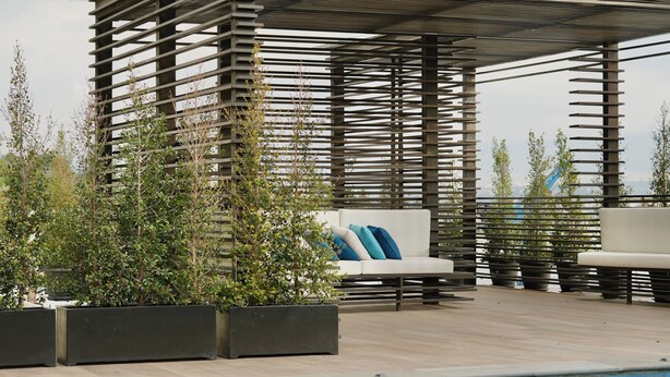A pool area with a wooden pergola, seating, and potted plants. - Apartments in Cumbaya near Airport (Cumbayá)