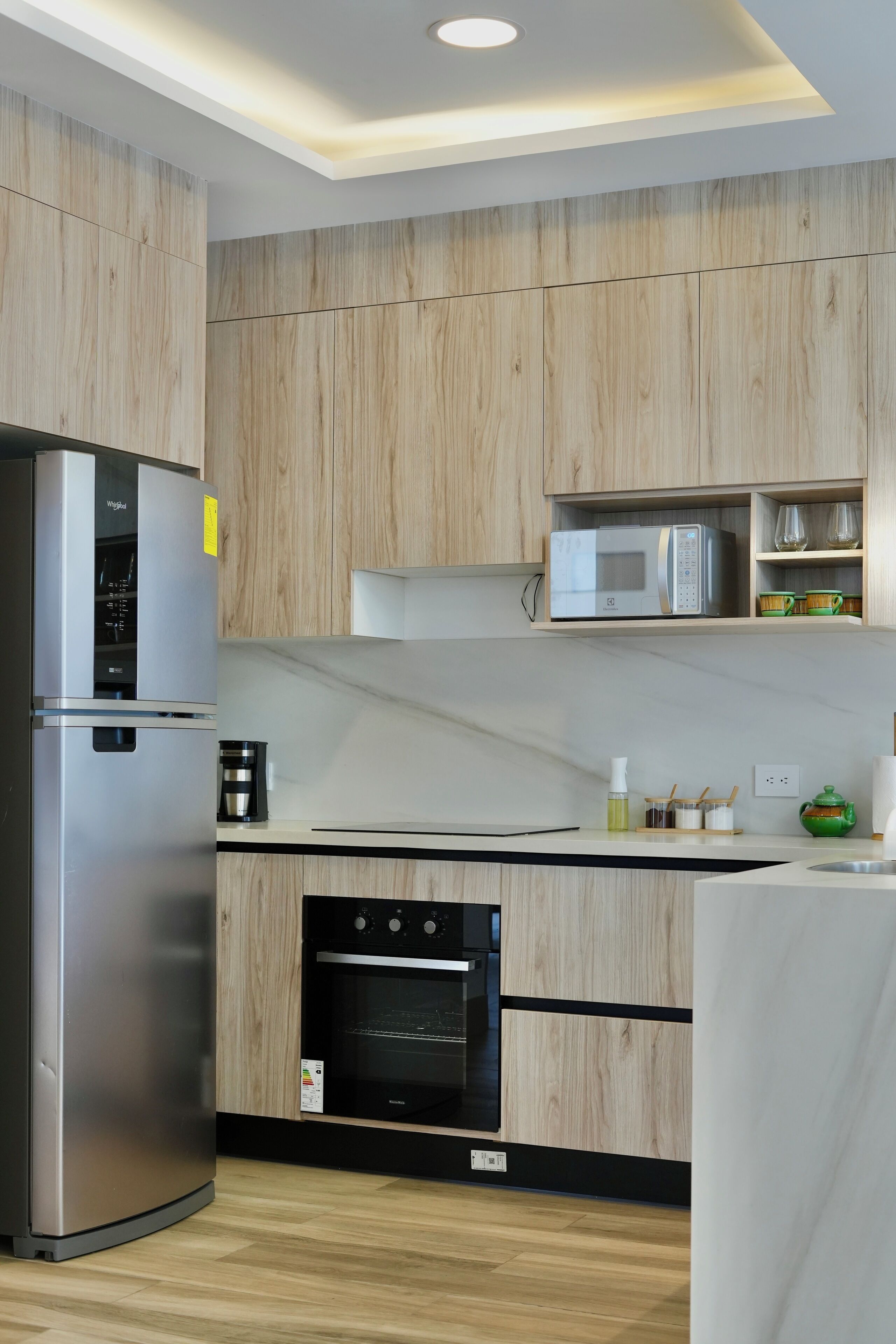 Una cucina moderna con mobili in legno, elettrodomestici in acciaio inossidabile e forno integrato.