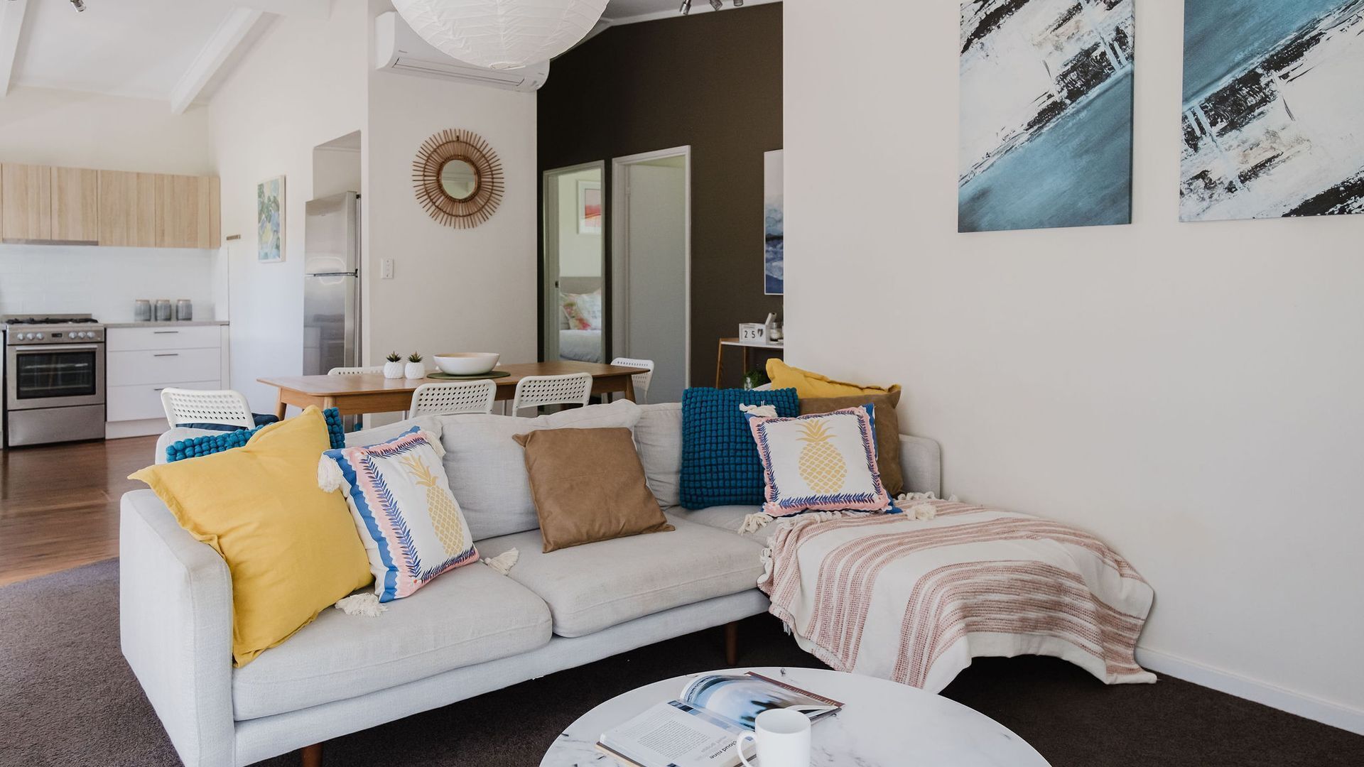 Ein modernes Wohnzimmer mit einer Couch, einem Couchtisch und Kunstwerken an den Wänden.