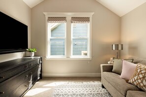 A room with a large window, a dark wooden dresser, a patterned rug, and a sofa with cushions. - 5-Bedroom Park City Old Town Daly Overlook with stunning mountain views. (Park City)