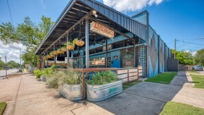 A building with a sign reading 'LOUNGE' and a sign for 'Chinks Lounge' with outdoor seating and hanging plants. - 🎶 East Austin Retreat w/ Balcony + Backyard | Urban Sanctuary | Cloudscape🌮 (Austin)