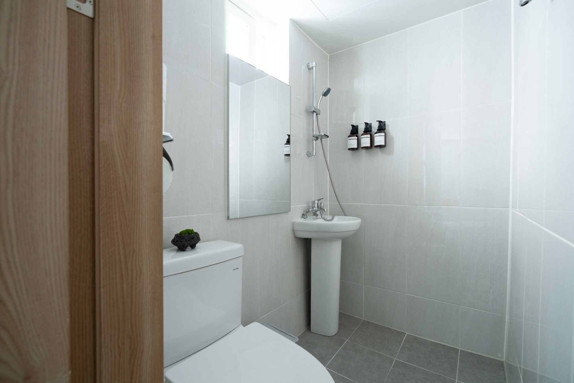 A modern bathroom with a toilet, sink, and shower.