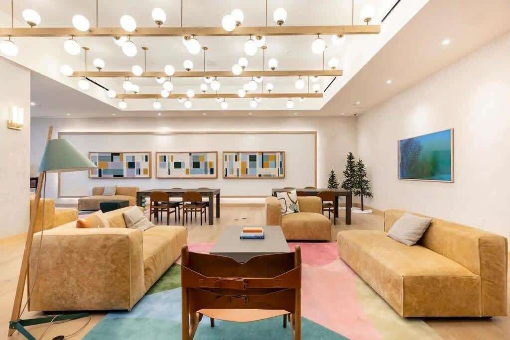 A modern living room with a sofa, chairs, a coffee table, and artwork on the walls.