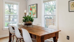 A dining area with a wooden table, white chairs, and a potted plant. - Walkable, Prime E. Austin Location - Casa Cherico (Austin)