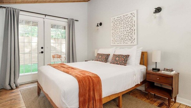 Een slaapkamer met een bed, een nachtkastje, een wandlamp en een decoratief object.