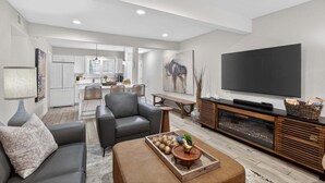 Una sala de estar moderna con sofá, mesa de centro y televisor.