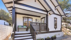 A two-story house with a covered porch, a staircase, and a fenced yard. - 🌿 SoCo Retreat by Creek with Workspace | Creekside Bungalow 🎶 (Austin)