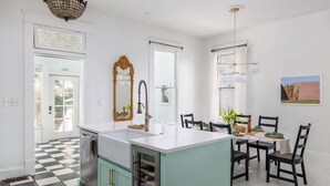 A kitchen with a checkered floor, a central island, and a dining area with chairs and a table. - Free Parking, Walk to Zilker, 3BR - Austin Craftsman (Austin)