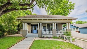 A single-story house with a front porch, a visible garage door, and a small front yard. - Free Parking, Walk to Zilker, 3BR - Austin Craftsman (Austin)