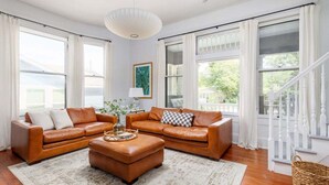 A living room with two brown leather sofas, a matching ottoman, and a patterned rug. - Free Parking, Walk to Zilker, 3BR - Austin Craftsman (Austin)