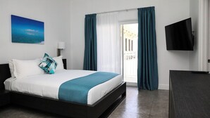 Una camera d'albergo moderna con un letto, una TV, un quadro e vista sull'esterno.
