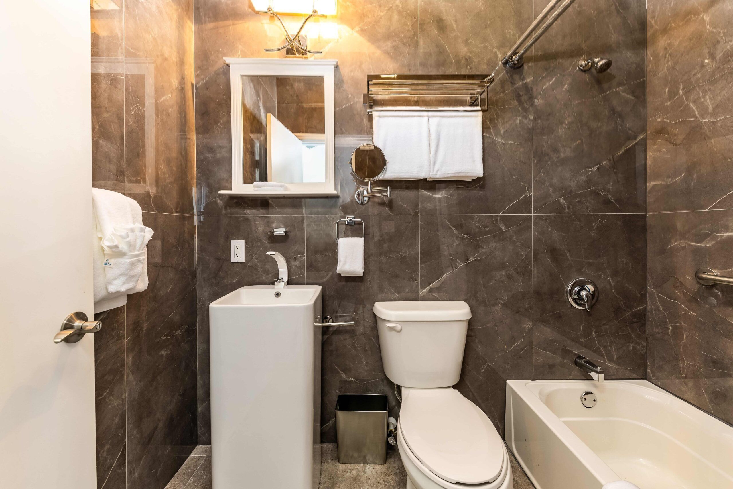 A modern bathroom with a toilet, sink, and bathtub.