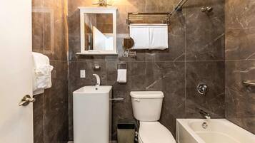 A modern bathroom with a toilet, sink, and bathtub.