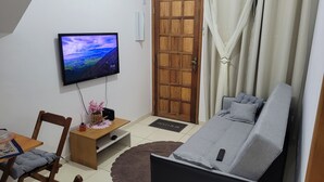 Una sala de estar moderna con un televisor de pantalla plana, muebles de madera y un sofá acogedor.