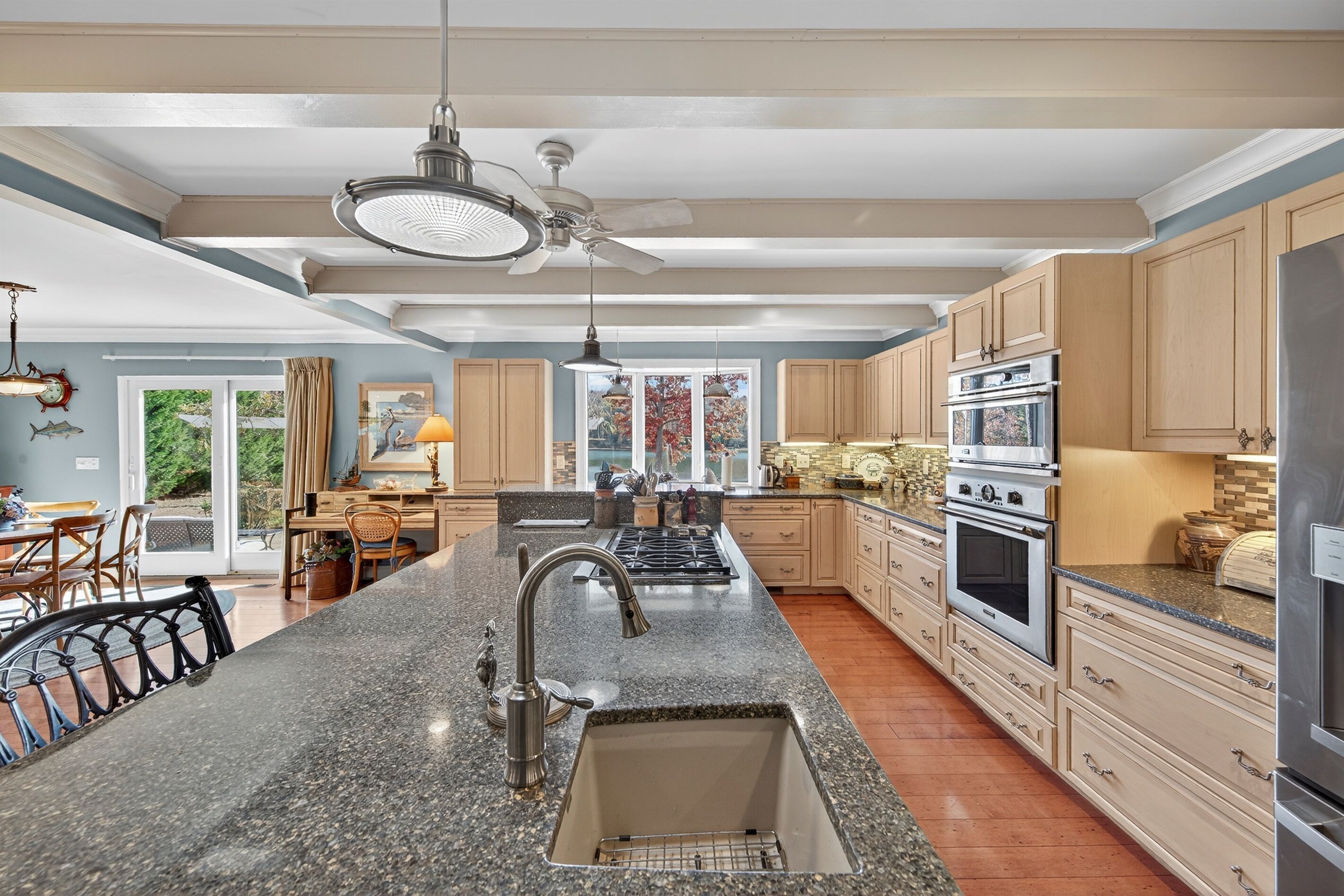 A spacious kitchen with granite countertops, stainless steel appliances, and wooden cabinets.