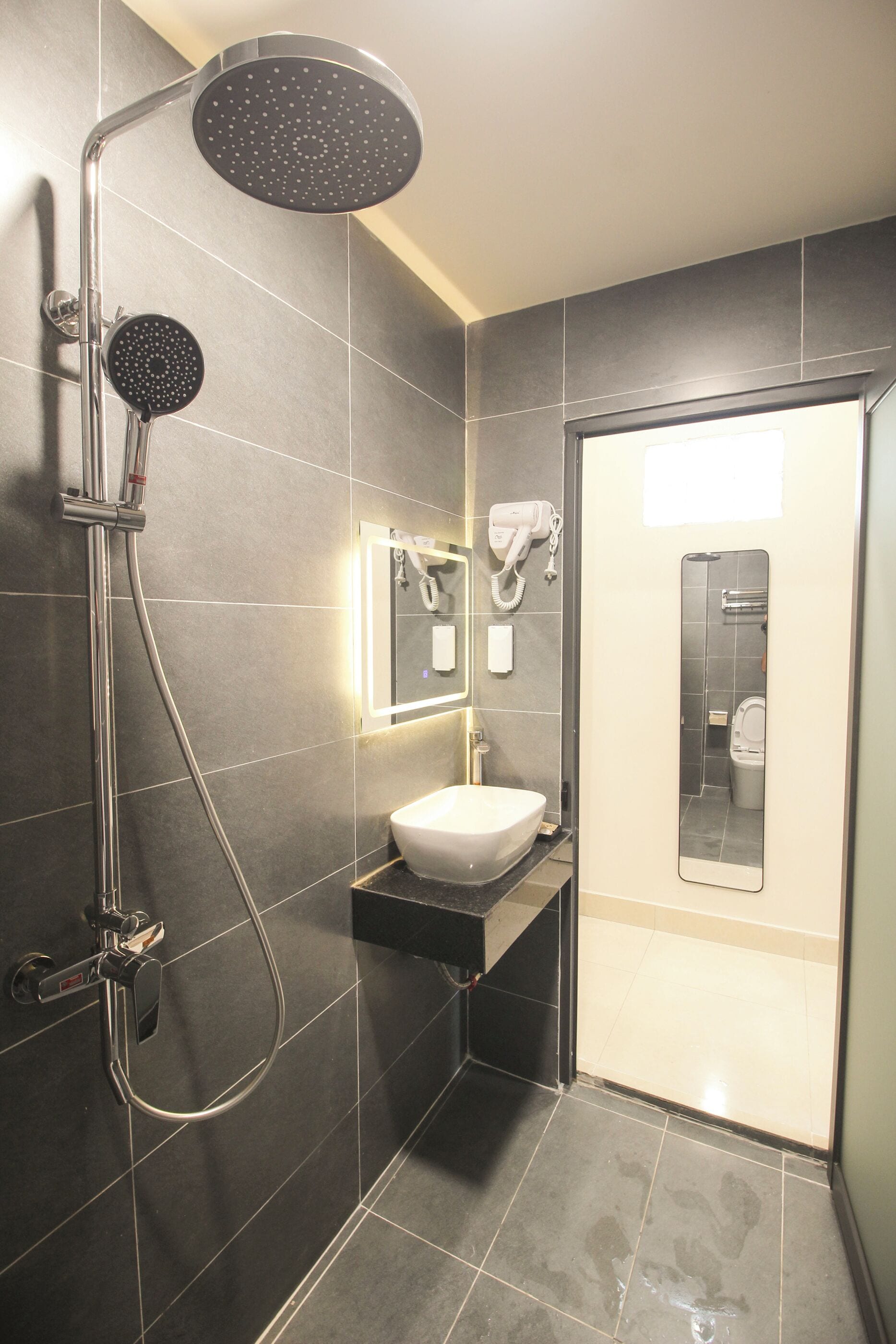A modern bathroom with a shower, sink, and a mirror.
