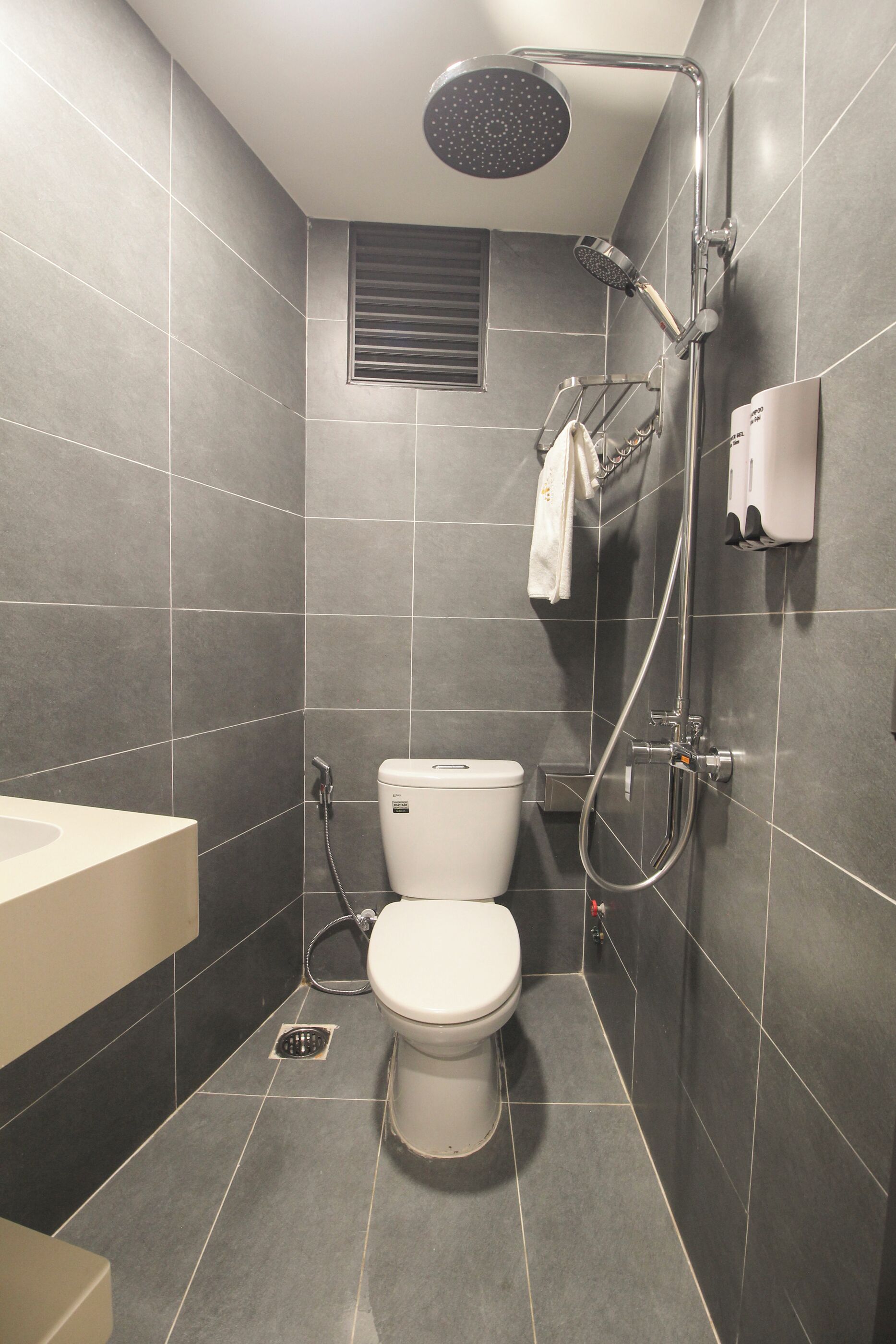 A modern bathroom with a toilet, shower, and sink.