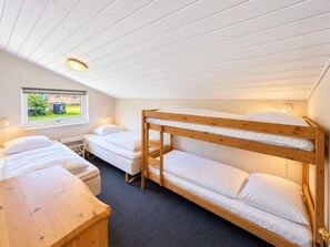 A dormitory room with bunk beds, a desk, and a window with a view of greenery. - 12 Person Holiday Home in Oksbol (Oksbol)