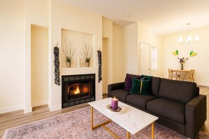 Ein Wohnzimmer mit Kamin, einer Couch, einem Couchtisch und einem Essbereich.
