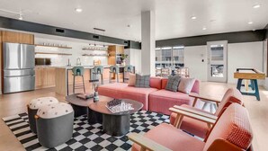 A modern living room with a pink sofa, a coffee table, and a checkered rug.