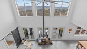 Un loft spacieux doté d’une grande verrière, d’une cheminée centrale et offrant une vue sur l’extérieur.