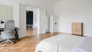 Una habitación de hotel moderna con cama, escritorio y armario.