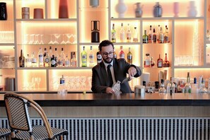 A bar area with shelves of liquor bottles and glasses. - Thalazur St Jean de Luz (Saint-Jean-de-Luz)