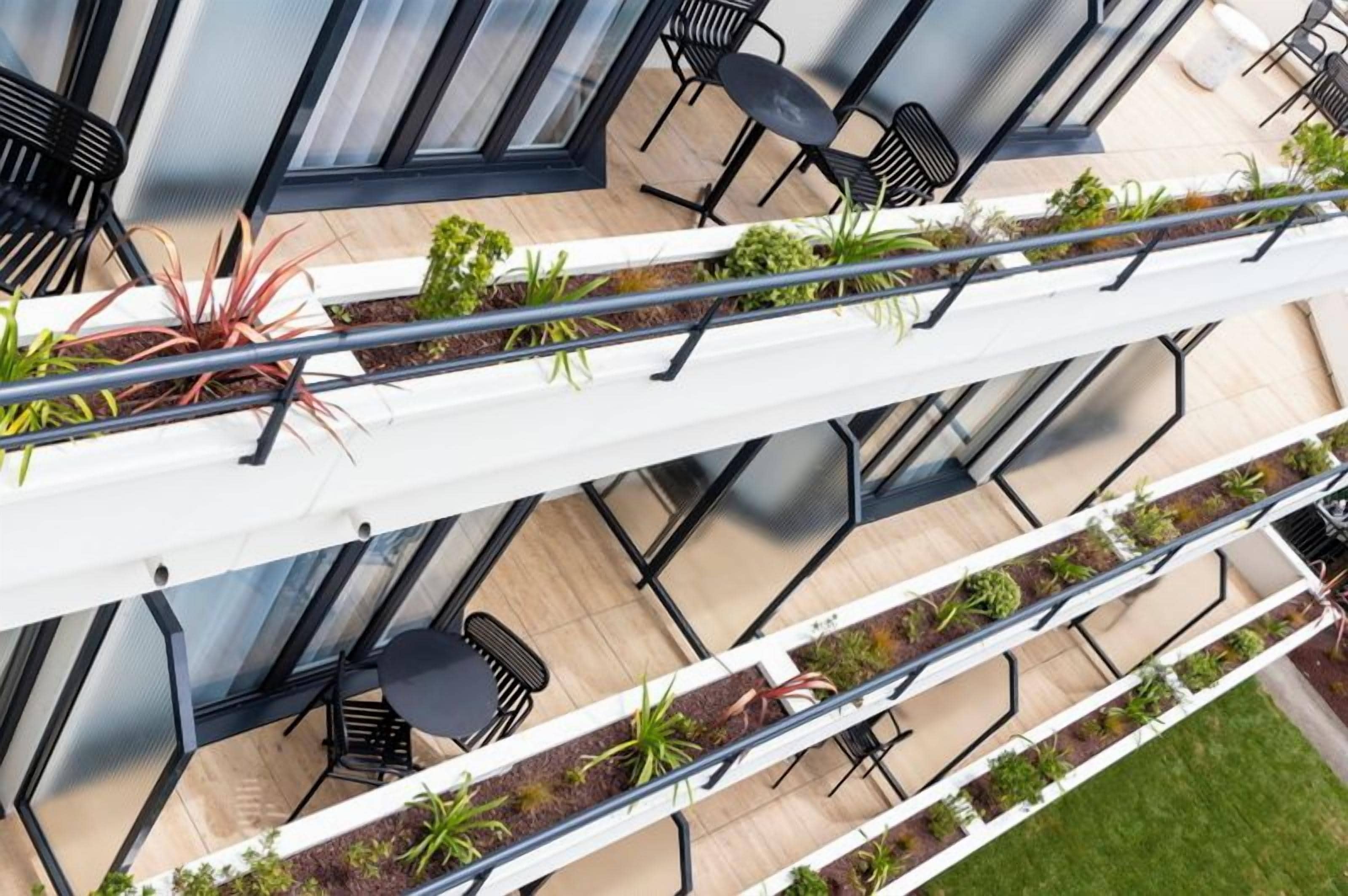 Una terraza al aire libre de varios niveles con zonas de estar y jardineras.