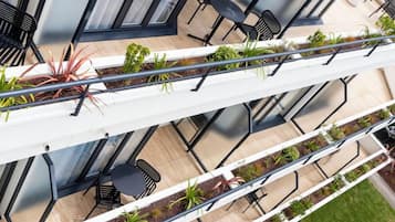 Una terraza al aire libre de varios niveles con zonas de estar y jardineras.