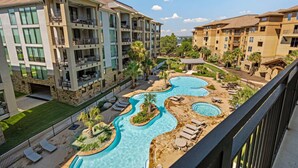 Un hôtel comprenant plusieurs étages, doté de piscines extérieures et d’un vaste espace vert bien entretenu.