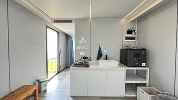 A modern kitchen with a central island, white cabinetry, and a built-in microwave.