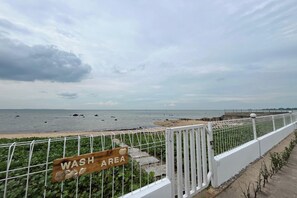 A coastal view with a 'WASH AREA' sign, a white fence, and a beach in the background. - Saga Village Hotel & Resort Bintan By Zuzu (Bintan)