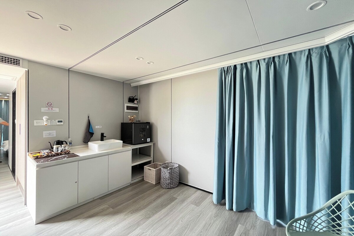 A modern kitchen with a built-in sink, a small island with a coffee maker, and a basket.