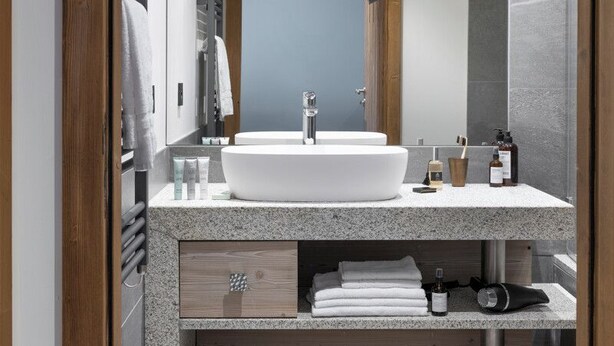 A modern bathroom with a large white sink, wooden beams, and a mirror. - MGM Hôtels et Résidences - Hotel Laska (Les Contamines-Montjoie)