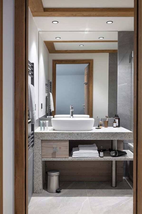 A modern bathroom with a large white sink, wooden beams, and a mirror. - MGM Hôtels et Résidences - Hotel Laska (Les Contamines-Montjoie)