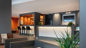 A modern hotel lobby with a reception desk, seating area, and bar. - MGM Hôtels et Résidences - Hotel Laska (Les Contamines-Montjoie)