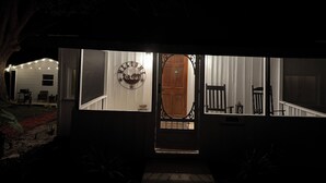 Une entrée de maison avec une pancarte de bienvenue, une porte en bois et un escalier menant à l’intérieur.
