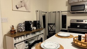 Une cuisine équipée d’un four à micro-ondes, d’une machine à café et d’un panneau indiquant « produits de la ferme à l’assiette ».