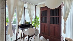 Ein Zimmer mit einem Holzkasten, einem Tisch mit Flaschen, einer Topfpflanze und einer Hängeleuchte.